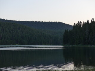 Part of a lake surrounded by mountains