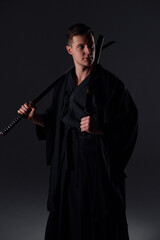 Samurai ninja warrior in kimono in attack pose with katana sword. dark room. sword shine. fighter. japanese culture