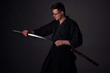 Samurai ninja warrior in kimono in attack pose with katana sword. dark room. sword shine. fighter. japanese culture