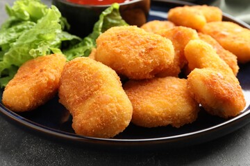 Tasty chicken nuggets on grey table, closeup