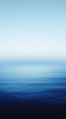 Fototapeta premium Calm ocean water with gradient from dark navy to light blue creates serene atmosphere