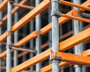 Detailed view of scaffolding with orange and metallic structure, showcasing construction safety and professional work environment.