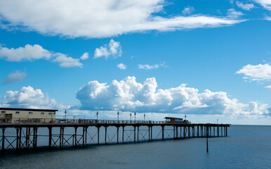 Obraz premium Cumulus clouds over the ocean. Sunlit clouds form over the south Devon coast. Strong contrast shown in these rain bearing clouds. Meteorology and weather image. Rainfall and precipitation. 