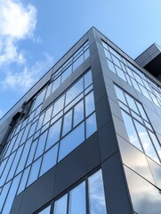 A modern office building with a graphite facade and large windows, reflecting the blue sky and white clouds. The building symbolizes progress, innovation, and a bright future.