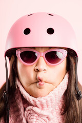 Duck face, helmet and sunglasses with woman in studio isolated on pink background for cycling. Eyewear, funny and safety with playful person joking on color wall for fashion, fitness or humor