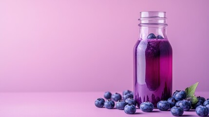 A bottle of purple beverage with blueberries on a pastel pink background.