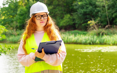 Female ecologist records environmental data. Women ecologist with a tablet checks trees. Forestry engineer inspector.