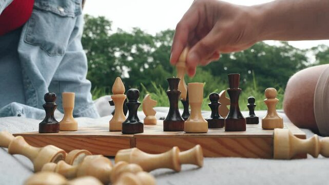 Chess, close-up, hands, chessboard. Enjoying a delightful game of chess in park on a lovely summer afternoon creates a charming atmosphere for a casual date that encompasses fun, excitement, intimacy