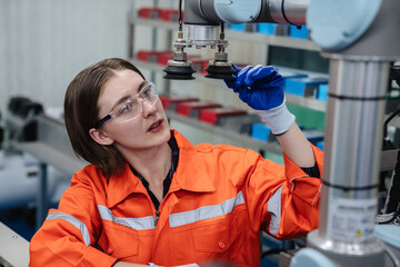 Student engineer assembles a robotic arm in a technology workshop. Engineer holds a robot...
