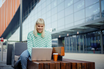 A young traveler is working freelance job on city street.