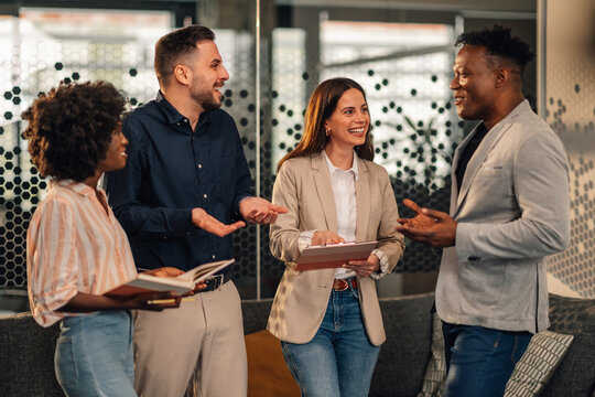 Happy diverse causal executives working on business strategy at lobby.
