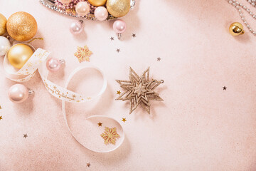 Festive Christmas and New Year background with gold and pink baubles, ribbons and stars. White ribbon with Merry Christmas written. Flat lay, top view with copy space