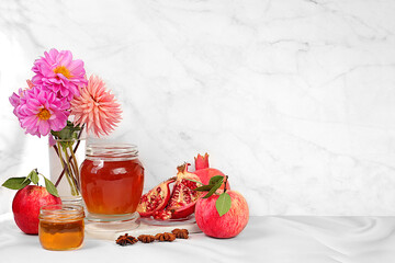 Autumn banner with honey, apples, pomegranates, flowers, dried fruits on light background,...