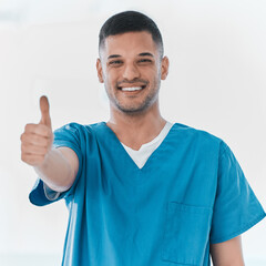 Fototapeta premium Portrait, surgeon and happy man with thumbs up in studio for success, welcome and thank you. India, doctor or proud medical nurse with hand gesture for approval, agreement or yes on white background
