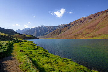 Chandratal lake, Moon Lake during Sunset with crystal clear water in between mountains surrounded by snowcapped mountains.