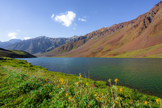 Chandratal lake, Moon Lake during Sunset with crystal clear water in between mountains surrounded by snowcapped mountains.