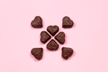 Heart-shaped chocolate candy on a pink background