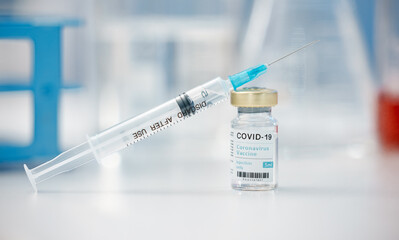 Needle, covid or vaccine with vial on table for cure, pandemic or flu shot at hospital or clinic....