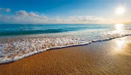 太陽の光を浴びて黄金色に輝く砂浜の写真。目の前にはクリスタルブルーの海が広がり、柔らかな波が砂浜に寄せては返す。波打ち際には細かい泡が残り、穏やかな風が優しく吹き抜ける。