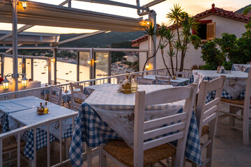 Greek restaurant at sunset. Summer holidays in Greece. Romantic moments on vacation