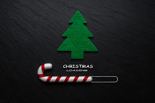 Creative layout made of Candy cane with Christmas tree on black stone background. Minimal Christmas loading concept.