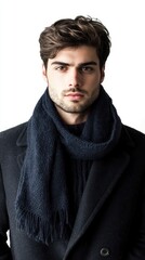 Obraz premium A man showcases elegant winter fashion featuring a wool coat and a stylish knitted scarf, set against a clean white backdrop