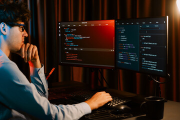 Working IT developer concentrating online software development information on surrounded by coding application pc screens, creating program for firmware on website at neon modern office home. Gusher.