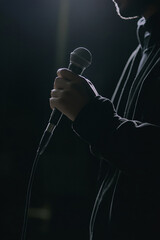 a handsome young man singing into a microphone, a portrait.
