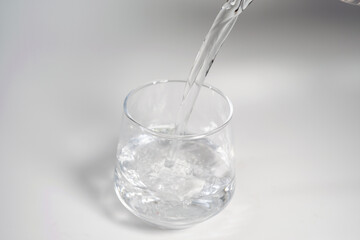 Pour Water Into Empty Glass Isolated On White Background