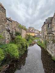 Views of historic colorful homes alongside a river with trees while in Edinburgh, Scotland