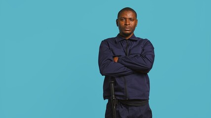 Portrait of smiling security agent securing assigned post, isolated against studio background....