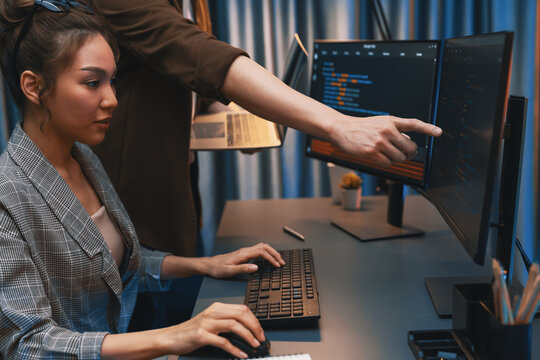 Serious of IT developers discussing intelligent website development coder system running data online two screens with laptop showing information network at neon light room at modern office. Infobahn.