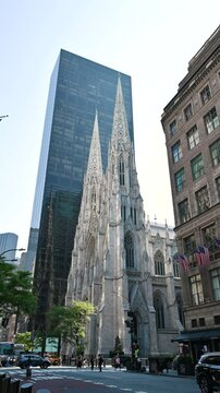 New York City, USA, August 14, 2024. Beautiful vertical fixed shot footage of St. Patrick's Cathedral. Gothic in style, it stands out from the modern skyscrapers that surround it.