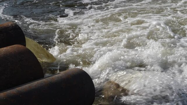 dirty waste water flows from a pipe into a river polluting and poisoning fresh water, industrial waste, industrial water is discharged into a reservoir, problems of ecology and fresh water