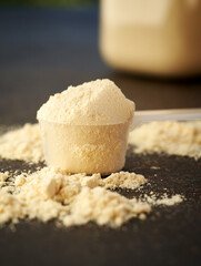 Whey protein powder in a measuring spoon