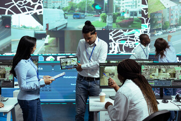Indian manager presenting a new satellite navigation to locate truck drivers in traffic, using...