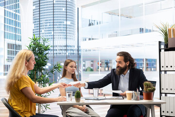 Financial adviser providing clients with informative leaflets on retirement planning, tax issues and wealth management. Agent in office assisting clients in setting up investment accounts