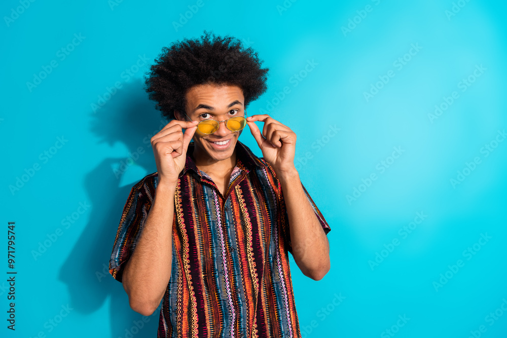 Poster Photo of nice young man touch sunglass empty space wear shirt isolated on teal color background