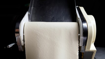 Pasta machine rolling dough for delicious homemade pasta
