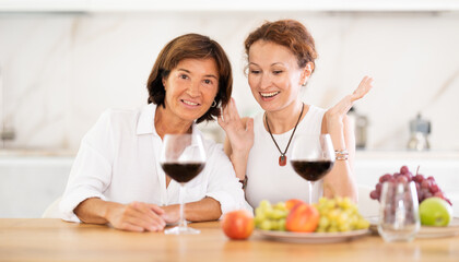 Party for two girlfriends - women drinking wine and telling each other news