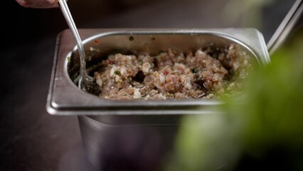 Chef preparing ingredients with spices for a delicious meal.