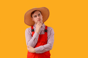 Thoughtful young farmer on yellow background