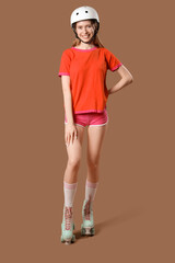 Beautiful young woman in helmet and roller skates on brown background