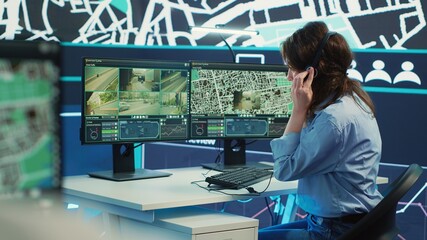Woman call center operator guiding delivery truck drivers on different routes to avoid traffic and help with express shipment. Agency uses surveillance CCTV video and gps tracking. Camera A.