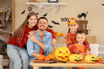 Happy family with Halloween pumpkins hugging at home