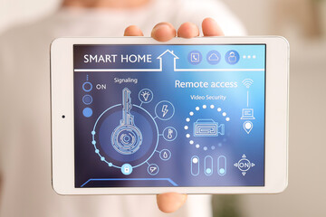 Young man with smart home control panel in kitchen, closeup