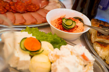 ham, roast beef and sausage served with vegetables and salad, as well as peppers with sour cream