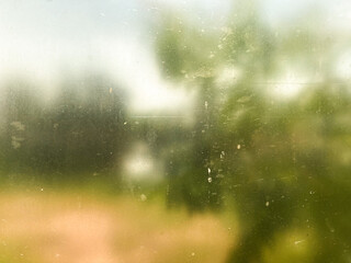 Abstract blurred nature scene through a dusty glass window. Perfect for background textures and artistic designs
