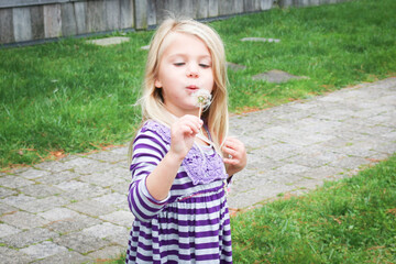 girl blowing dandelion