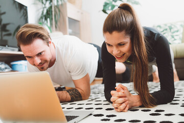 Fototapeta premium Young caucasian couple working out at home